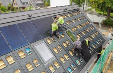 Drohnenaufnahme von oben. Mitarbeiter auf dem Dach für eine Photovoltaik-Installation