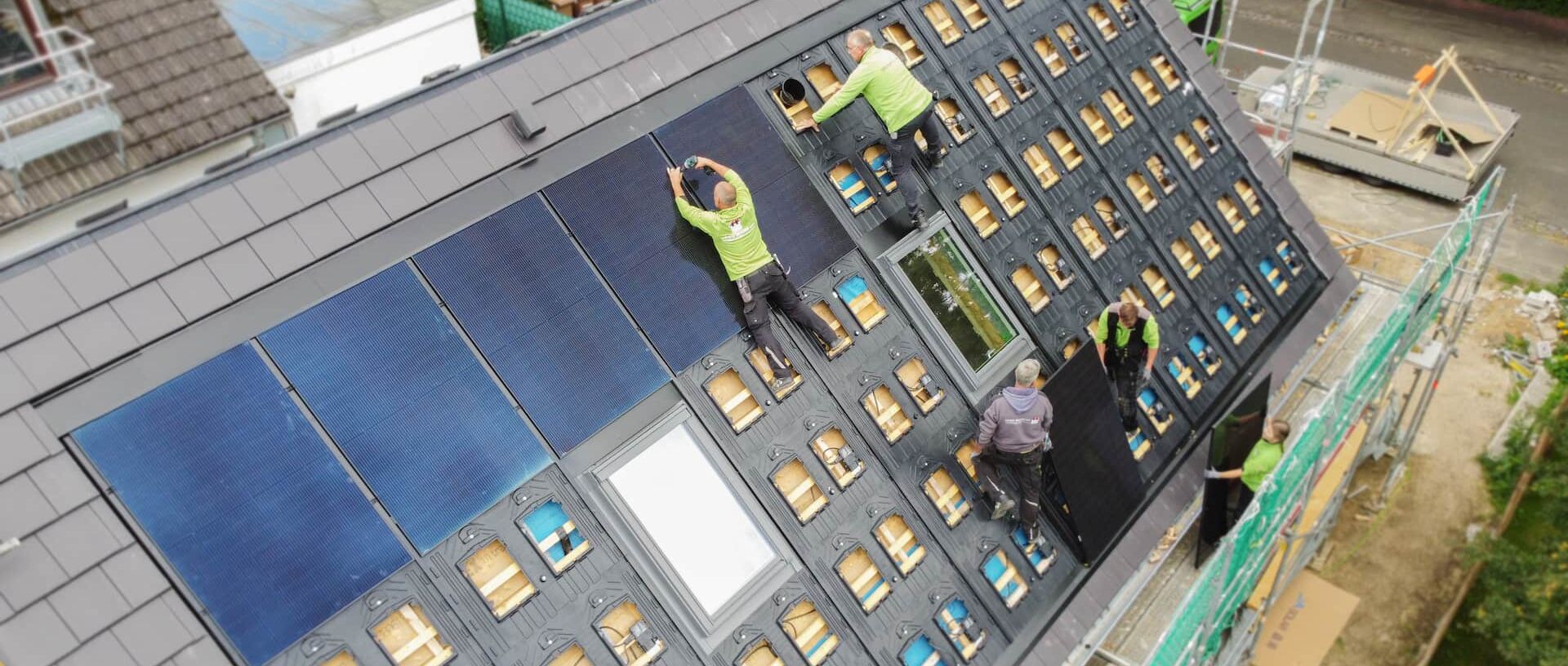 Drohnenaufnahme von oben. Mitarbeiter auf dem Dach für eine Photovoltaik-Installation