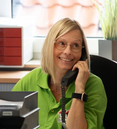 Porträtfoto Amika im Büro am Telefon