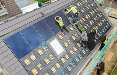 Drohnenaufnahme von oben. Mitarbeiter auf dem Dach für eine Photovoltaik-Installation