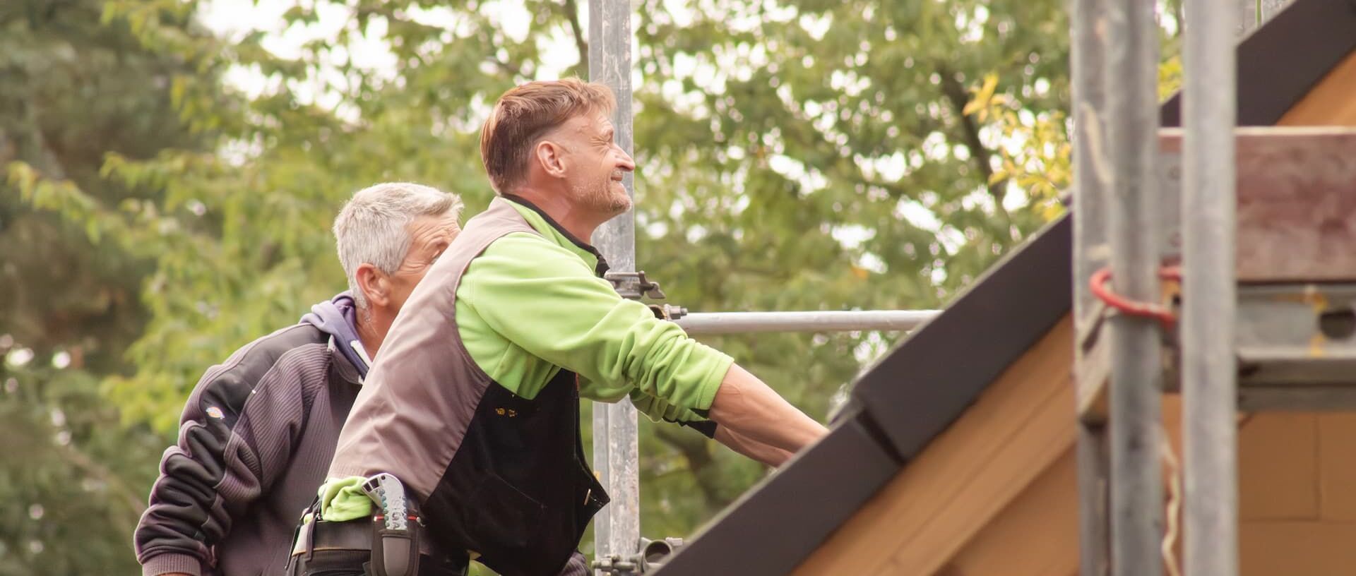 Auf dem Dach Drohnenaufnahme von oben. Mitarbeiter auf dem Dach für eine Photovoltaik-Installation